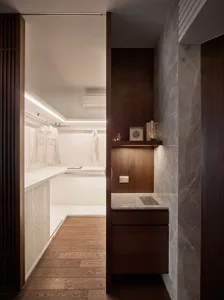 Modern closet with white marble countertops, wooden shelves, and a minimalist design.