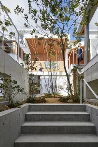 A modern industrial-style house featuring a concrete exterior and a central courtyard with greenery.