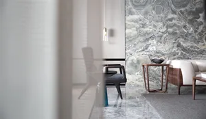A modern living room featuring marble walls and furniture.