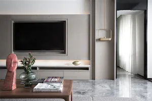 Contemporary living room with marble floor, minimalist decor, and natural light