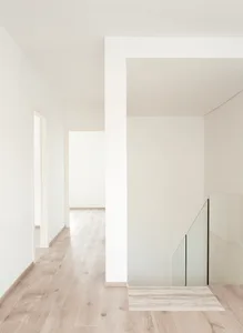 A minimalist house interior with white walls and wooden floor.