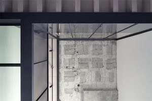 A minimalist interior space featuring a concrete wall and floor.