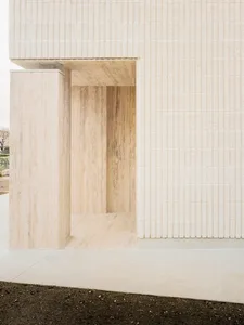 A minimalistic interior space with white marble walls and flooring.