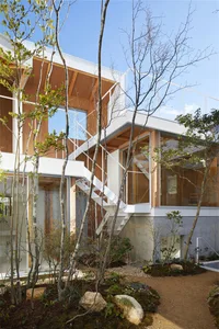 Modern architectural house with white walls, wooden elements, and glass windows.