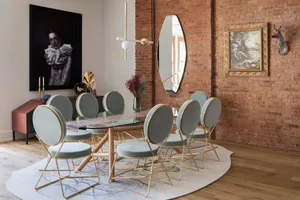 Modern dining room featuring glass table, metal-framed chairs, and wooden flooring.