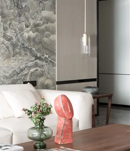 A modern living room features a white sofa adorned with a red sculpture and a green vase filled with greenery.