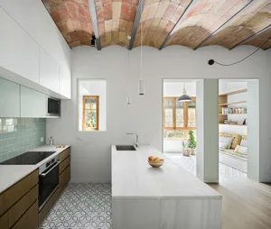 A modern kitchen with concrete countertops and a tiled floor.