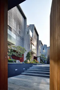 A modern building with metal and stone cladding situated on a cliffside.