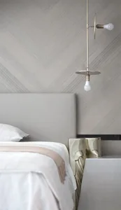 Modern, minimalist bedroom featuring a bed with metallic headboard and metallic side tables.