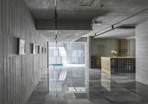 A modern minimalist building with a concrete exterior and geometric design features.
