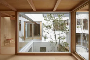 A minimalist interior design showcases a natural wooden floor and ceiling, with large windows allowing natural light to enter