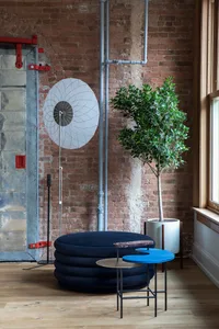 An industrial-style office space featuring a wooden floor, brick walls, and a modern seating area.