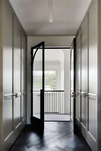 A modern interior with a black-framed glass door panel, showcasing clean lines and minimalist design features.