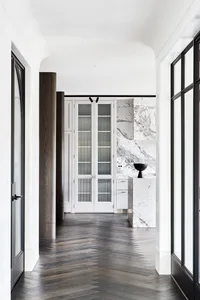 A modern interior with wooden and marble surfaces, and glass elements.
