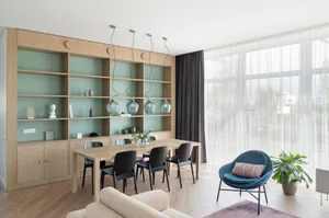 Modern living room with wooden shelving, black chairs, and a blue armchair.