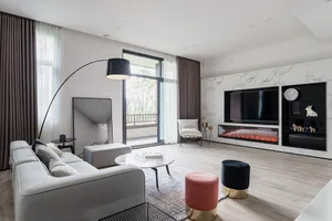 Modern living room featuring a concrete fireplace, marble accent wall, and minimalist furniture.