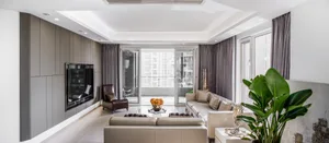 A modern living room featuring neutral-toned upholstery, large windows, and a sleek design aesthetic.