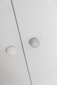 A white and marble door knob against a white background