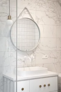 A modern minimalist bathroom with marble accents and a concrete countertop.