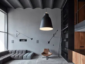 Industrial-style living room with concrete floor, wooden shelving, and metal fixtures.