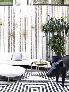 Modern minimalist interior with metallic wall art and geometric floor tiles.
