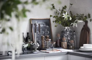 A minimalist white kitchen with ceramic elements and a chalkboard menu displaying coffee drinks.