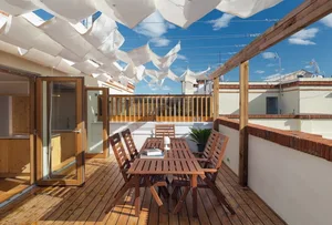 Modern balcony featuring wooden terrace under a canopy of white fabric.