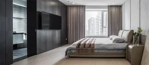 A modern bedroom featuring a wooden board and batten wall with a large bed, a mounted flat-screen TV on the wall, and a windo