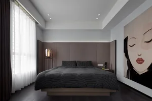 A modern bedroom featuring a wooden platform bed and a large, framed portrait of a woman's face.
