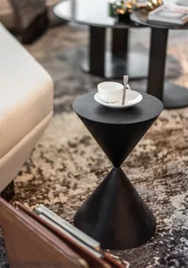 A modern black metal side table with a cone-shaped design, featuring a cup and saucer on top.