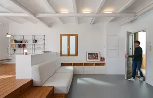 Minimalist living room with a wood sofa, concrete flooring, and metal accents.