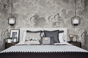 A minimalist bedroom with a bed adorned with plush pillows and decorative accents, set against a dramatic, textured wallpaper