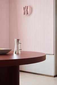 A minimalist functional zone featuring a metallic table with a bowl and a metallic jug on it.