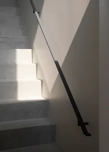 A minimalist staircase with concrete steps illuminated by natural light.