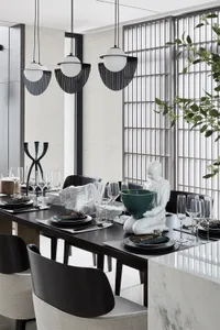 A modern dining room featuring black steel and marble materials.