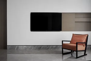 Modern living room featuring a metal frame armchair with a leather cushion.