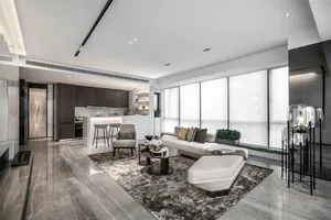 Contemporary living room with marble flooring, minimalist furniture, and large windows.