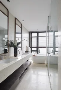 A modern minimalist bathroom with glass features, including a freestanding bathtub and a walk-in shower.
