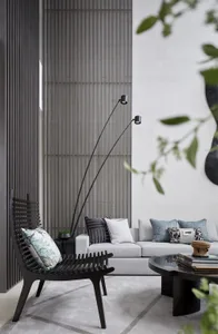 Modern minimalist living room featuring a sleek concrete wall, grey sofa, and black armchair