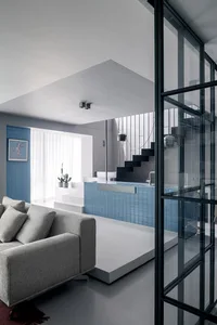 Modern living room with blue tiles and cement floor