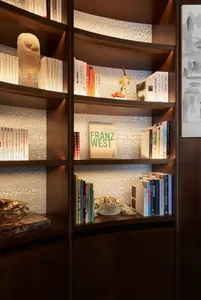 A modern bookshelf filled with books and sculptures.
