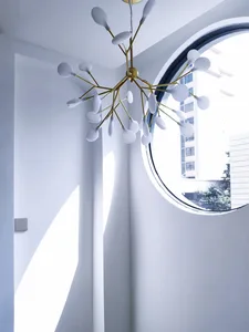 Modern minimalist interior with metallic chandelier and circular window.
