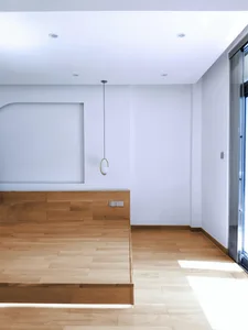 Minimalist bedroom with wooden flooring, emphasizing a modern and clean design.