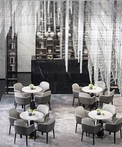 Modern cafe interior with marble furniture and white decor.
