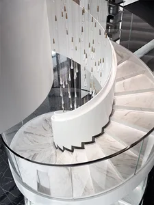 Coiled staircase with marble steps, glass railings, and metallic elements.