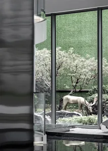 Modern interior with floor-to-ceiling glass walls and greenery