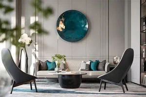 Modern living room with gray and green accents, featuring a white sofa, black chairs, and decorative elements like a large ro