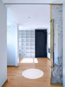 A modern lobby featuring a glass wall, illuminated by natural light.