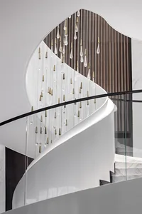 A modern staircase features glass, bronze, and metal details.