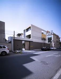 Modern, minimalist exterior of a townhome with concrete walls and large windows.